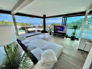 a living room with a white couch and a tv at The Beach Hytte - Stunning Sea View Penthouse in Bournemouth