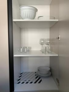 a cupboard with plates and bowls on a shelf at NATURE in Lugano