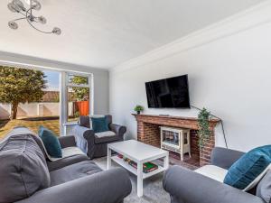 a living room with two couches and a fireplace at Pass The Keys Lovely Ground Floor Flat With Large Garden in Chichester