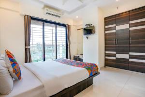 a bedroom with a bed and a large window at FabHotel Zaika Orchid Apartment in Mumbai
