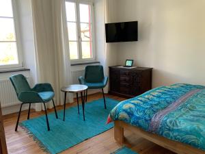 a bedroom with two chairs and a bed and a desk at Ferienhaus Mosel 2.0 in Bremm