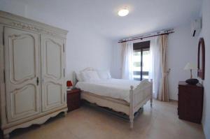 マルベーリャにあるLa Maestranzaのベッドルーム(大きな白いベッド1台、窓付)