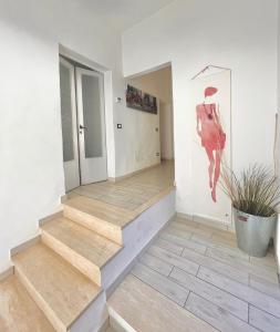 un pasillo con escaleras y una pintura de una mujer con sombrilla en Appartamento Merilu, en Civita Castellana