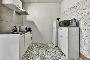 a small kitchen with white appliances and a tile floor at Appartement L'Elégant Chalonnais - Hyper-Centre in Chalon-sur-Saône