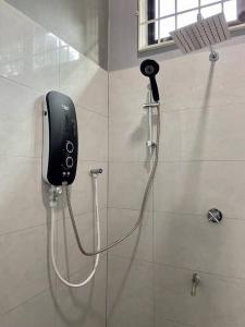 a phone on the wall of a shower in a bathroom at Homestay Ummi D'Pauh in Kota Bharu