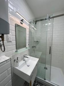 a bathroom with a sink and a glass shower at Lujza Apartman in Fonyód