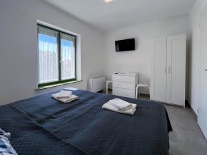 una camera da letto con un letto con due asciugamani sopra di Lujza Apartman a Fonyód