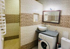 a bathroom with a washing machine and a sink at Ogienka 2b, Center Lutsk in Lutsk