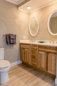 a bathroom with a toilet and a sink and two mirrors at Strictly Moose Luxury Vacation Suites in Gorham