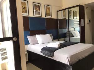 een slaapkamer met een groot bed en een spiegel bij Mabolo Garden Flat a1 Rooftop Pool Near Ayala Mall in Cebu City