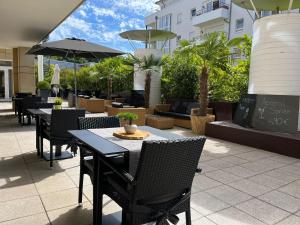 a patio with tables and chairs and umbrellas at City Hotel Frankfurt Bad Vilbel in Bad Vilbel
