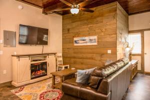 a living room with a couch and a fireplace at Strictly Moose Luxury Vacation Suites in Gorham
