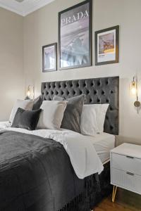 a bedroom with a large bed and two pictures on the wall at Stunning Georgian Apartment In Yorkshire - Parking in Wakefield