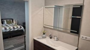 a bathroom with a sink and a mirror and a bed at Dill Hotel in Ilsede