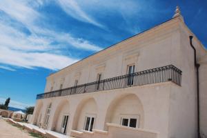 a building with a balcony on the side of it at Antica Masseria Malvezzi in Matera