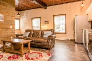 a living room with a couch and a refrigerator at Strictly Moose Luxury Vacation Suites in Gorham