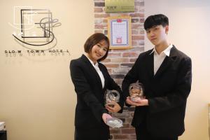 台北的住宿－漫映旅舍，两人穿着西装,正在颁奖