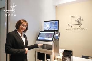 a woman standing in front of a cash register at Slow Town Hotel-Reel in Taipei