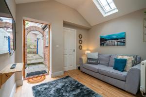 een woonkamer met een bank en een raam bij 18th Century Townhouse in Chester city centre in Chester