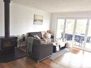 a living room with a couch and a fireplace at Lakeview House LILAC in Chittaway Point