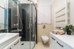 y baño con ducha, aseo y lavamanos. en Flatbook Apartamenty - Kąty Rybackie Marina en Kąty Rybackie