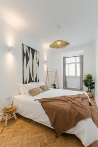 ein weißes Schlafzimmer mit einem großen Bett in einem Zimmer in der Unterkunft Casa Boma Lisboa - Shining & Spacious Apartments With Balcony - Alvalade I in Lissabon
