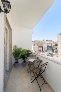 eine Terrasse mit einem Tisch und Stühlen auf dem Balkon in der Unterkunft Casa Boma Lisboa - Shining & Spacious Apartments With Balcony - Alvalade I in Lissabon
