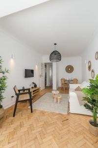 ein Wohnzimmer mit einem weißen Sofa und einem Tisch in der Unterkunft Casa Boma Lisboa - Shining & Spacious Apartments With Balcony - Alvalade I in Lissabon