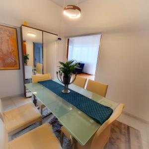 a dining room with a green table and chairs at City Center Apartment in Bucharest