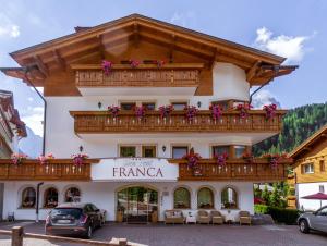 um edifício nas montanhas com uma varanda em Garni Hotel Franca b&b em Selva di Val Gardena