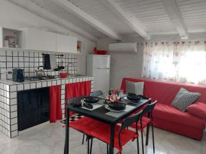 - un salon avec une table et un canapé rouge dans l'établissement Mamà Apartment, à Augusta
