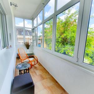 a room with windows and a table and a chair at City Center Apartment in Bucharest