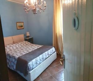 una camera con letto e lampadario a braccio di B&B Villa Giardini Susanna a Gattico