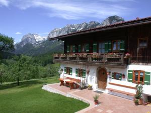 un edificio con un banco frente a él con montañas en Haus Langbruck Ferienwohnungen, en Ramsau