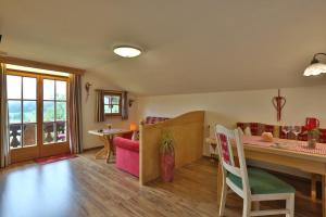 Una sala de estar con un escritorio, una mesa y sillas. en Haus Langbruck Ferienwohnungen, en Ramsau