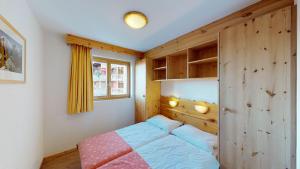 een slaapkamer met een bed en een houten muur bij Pracondu OUTDOOR & FUN appartement 8 personnes by Alpvision Résidences in Nendaz