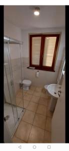 een badkamer met een douche, een toilet en een wastafel bij Green Garden in Viareggio