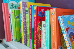una fila de libros sentados en un estante en Cozy with Character Cheerful Home with Garden at Leith Links Park, en Edimburgo