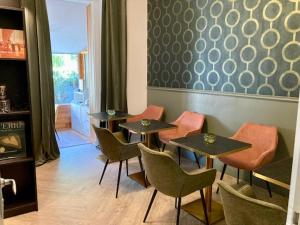 un restaurant avec quatre tables et chaises dans une pièce dans l'établissement Hôtel Coeur De Loire, à Nantes