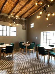 a dining room with tables and chairs and windows at CARASUR in Vista Flores