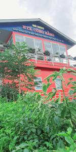un edificio rojo con un árbol delante de él en Mr.Khanh Coffee, en Xuân Trường