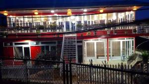 un edificio rojo con un balcón con plantas. en Mr.Khanh Coffee, en Xuân Trường