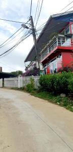 a house with a white fence next to a street at Mr.Khanh Coffee in Xuân Trường