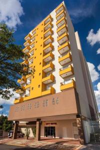 um edifício amarelo e branco com estacionamento em City Bauru Reserve Agora em Bauru