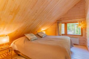 a bedroom with a bed in a wooden cabin at Patalaiska Cottages in Ruokolahti