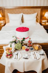 a table with food and flowers on a bed at Nadiya Hotel in Ivano-Frankivsk