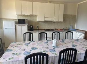 a kitchen with a table with chairs and a kitchen with white cabinets at Casa Fontanera in Gravedona