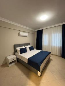 um quarto com uma cama grande com lençóis e almofadas azuis em THE HALCYON APARTMENT em Fethiye