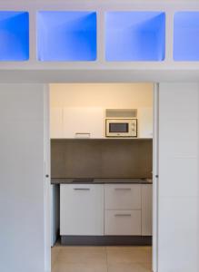 a kitchen with white cabinets and a microwave at Hyde Park Lane in Puerto del Carmen +101 photos