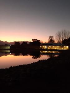 - une vue sur un bâtiment avec une réflexion dans l'eau dans l'établissement CARASUR, à Vista Flores